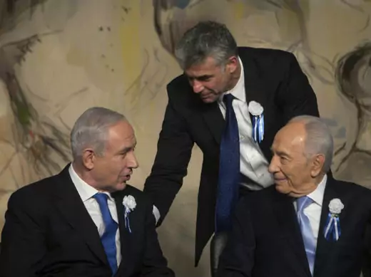Yair Lapid, head of Yesh Atid party stands behind Israel's prime minister Benjamin Netanyahu and president Shimon Peres at a reception following the swearing-in ceremony of the 19th Knesset, the new Israeli parliament, in Jerusalem February 5, 2013 (Zvulun/Courtesy Reuters)..