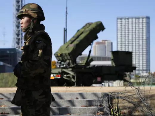 Members of the Japan Self-Defence Forces stand guard near Patriot Advanced Capability-3 (PAC-3) land-to-air missiles, deployed at the Defense Ministry in Tokyo