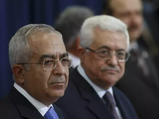 Palestinian president Mahmoud Abbas stands beside Salam Fayyad (L) during a swearing-in ceremony in the West Bank city of Ramallah May 19,2009 (Arouri/Courtesy Reuters).