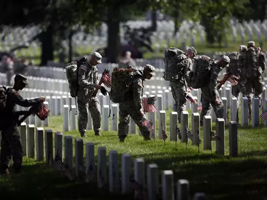 Members of the U.S. Army Old Guard place a flag at each of the more than 220,000 graves at Arlington National Cemetery (Jason Reed/Courtesy Reuters).