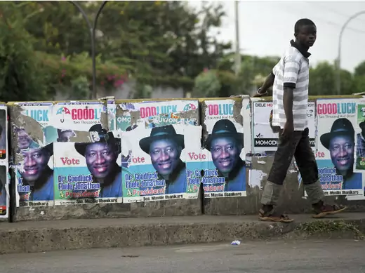 A man walks past election posters for Nigeria's President Goodluck Jonathan in the Maryland district of the commercial capital Lagos April 16, 2011.