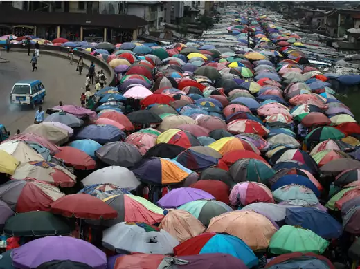 Street traders covers stalls with umbrellas along abandoned railway line in Nigeria's oil hub city of Port Harcourt December 3, 2012.