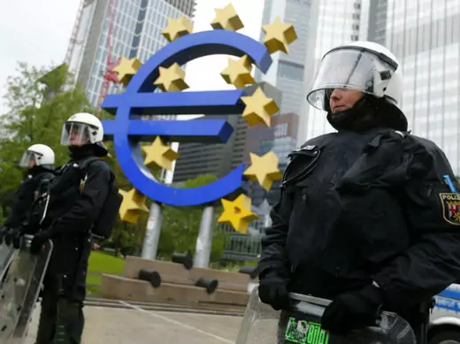 Global financial recessions have created pressure on democratic systems. Riot police stand near the euro sign in front of the European Central Bank (ECB) headquarters during an anti-capitalist "Blockupy" demonstration on May 31, 2013. 