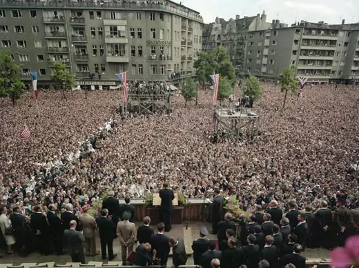 A crowd watches  President Kennedy as he delivers his “Ich bin ein Berliner” speech at Rudolph Wilde Platz in West Berlin (Robert Knudsen. White House Photographs. John F. Kennedy Presidential Library and Museum, Boston).