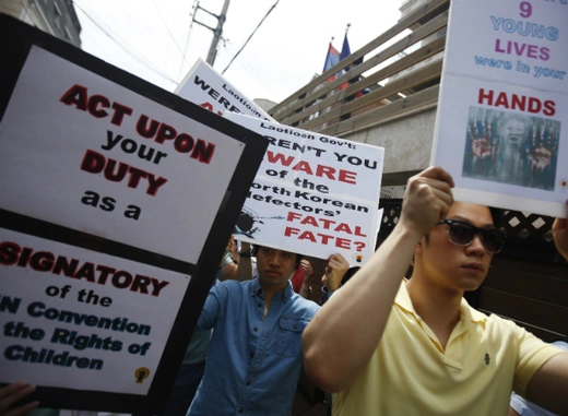 Protesters from a human rights group hold signs during a rally against Laos' recent repatriation of nine North Korean defectors, in front of the Laotian embassy in Seoul on May 31, 2013. (Kim Hong-Ji/Courtesy Reuters) 