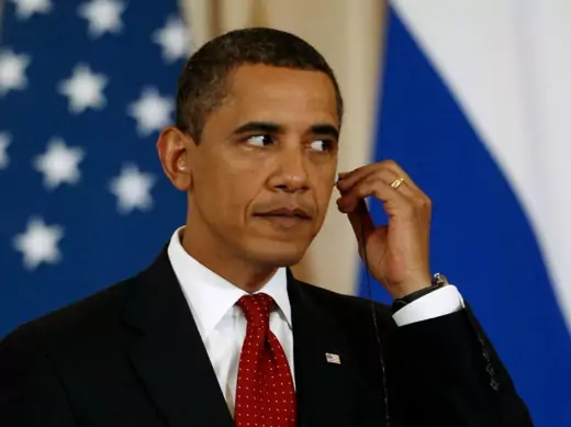 U.S. President Barack Obama adjusts his translators ear piece.