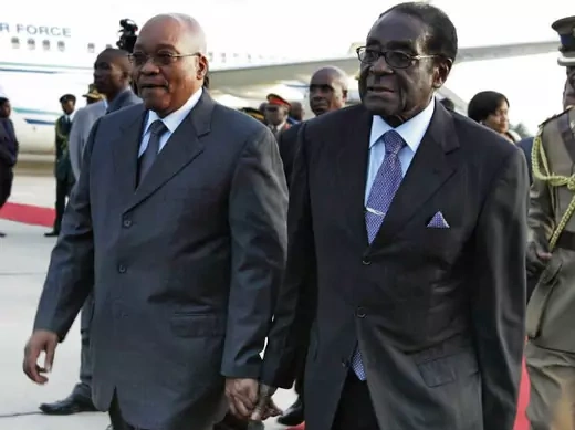 South African President Jacob Zuma (L) walks with Zimbabwean President Robert Mugabe at Harare International airport, March 16, 2010. 