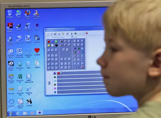 A first grade student listens during a computer lesson in school (Courtesy Reuters).