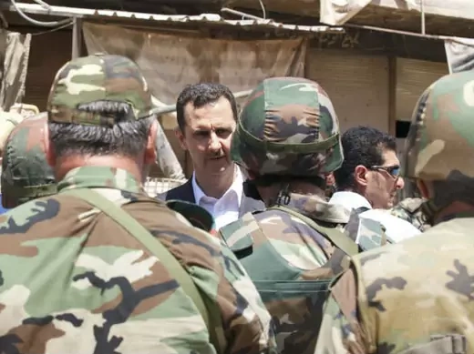 Syria's president Bashar al-Assad (C) chats with military personnel (SANA/Courtesy Reuters). 