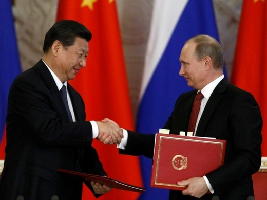 Russia's President Vladimir Putin (R) exchanges documents with his Chinese counterpart Xi Jinping during a signing ceremony at the Kremlin in Moscow on March 22, 2013.
