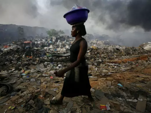 A woman walks through Olusosun rubbish dump in Nigeria's commercial capital Lagos, April 18, 2007.