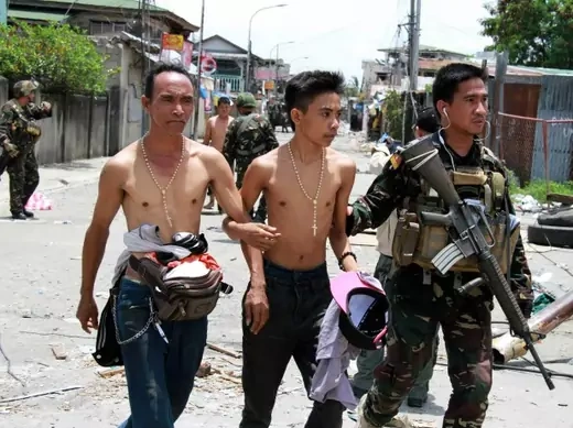 Government soldiers escort residents who were taken hostage and used as human shields by Muslim rebels of Moro National Liberation Front (MNLF) during fighting with government soldiers, in Zamboanga city in southern Philippines on September 17, 2013. (Stringer/Courtesy Reuters)