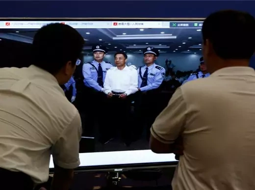 Men look at a screen displaying a picture of disgraced Chinese politician Bo Xilai standing trial on the website of a court's microblog, in Jinan, Shandong province on September 22, 2013 (Aly Song/Courtesy Reuters).