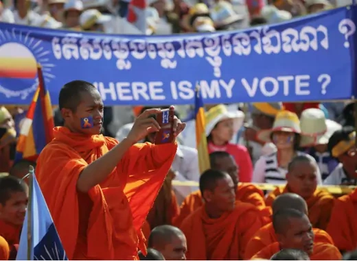 A Buddhist monk records the speech of one of the leaders of Cambodia National Rescue Party (CNRP) during a rally in Phnom Penh on September 7, 2013. (Damir Sagolj/Courtesy Reuters) 