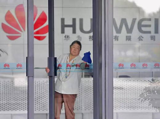 A cleaner wipes the glass door of a Huawei office in Wuhan, Hubei province (Courtesy Reuters).