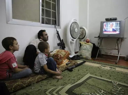 A Free Syrian Army fighter watches U.S. President Barack Obama's speech with his family in Ghouta, Damascus August 31, 2013 (Abdullah/Courtesy Reuters).
