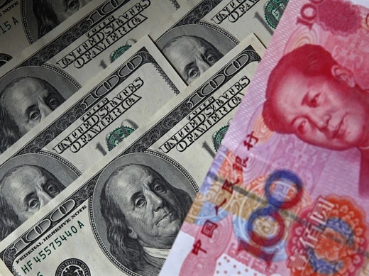 A 100 yuan banknote is placed next to $100 banknotes (Petar Kujundzic/Courtesy Reuters).