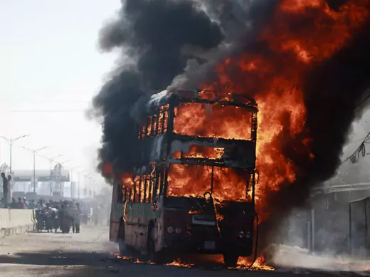 Smoke rises as a bus burns on a street after a nationwide strike was called, in Dhaka