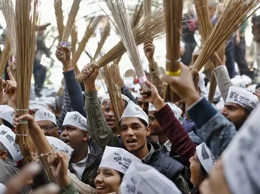 Supporters of Kejriwal, leader of the newly formed Aam Aadmi (Common Man) Party, hold brooms, the party's symbol, after Kejriwal's election win against Delhi's CM Dikshit, in New Delhi