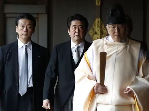 Japan's PM Abe is led by a Shinto priest as he visits Yasukuni shrine in Tokyo