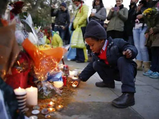 Wenceslous Nicholas, age four, lights a candle in front of the statue of former South African President Nelson Mandela in Parliament Square in central London December 8, 2013.