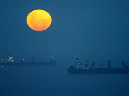 Ships lie at anchor outside the harbour at Durban, South Africa as a full moon rises on Boxing Day December 26, 2004.