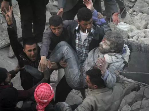 Residents react while calling for help as they hold an injured man that survived shelling after what activists said was an air strike from forces loyal to Syria's President Bashar al-Assad in Takeek Al-Bab area of Aleppo, December 17, 2013 (AboBrahim/Courtesy Reuters).