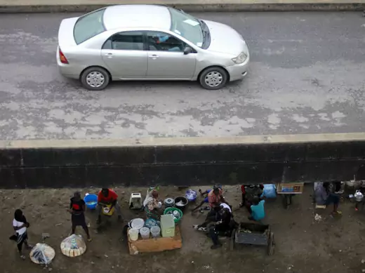 People sit and trade under a bridge at the Orile-Iganmu district of Lagos August 29, 2013