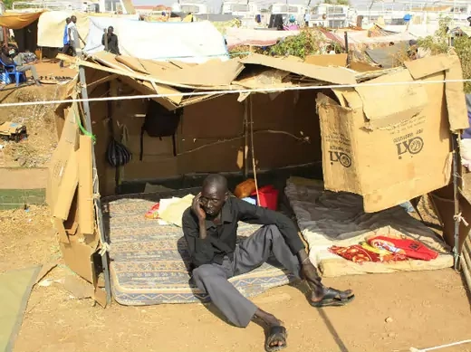 A displaced man speaks on a cellphone in his makeshift shelter at Tomping camp, where some 15,000 displaced people who fled their homes are sheltered by the United Nations, near South Sudan's capital Juba January 7, 2014.