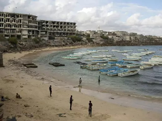 People stand and walk at a beach in the old port of Mogadishu November 13, 2013. 