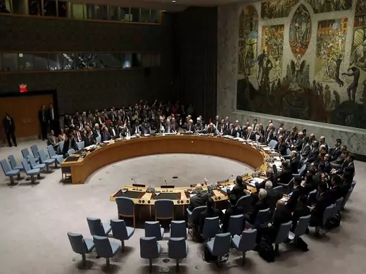 Members of the United Nations Security Council raise their hands as they vote unanimously to approve a resolution eradicating Syria's chemical arsenal in New York