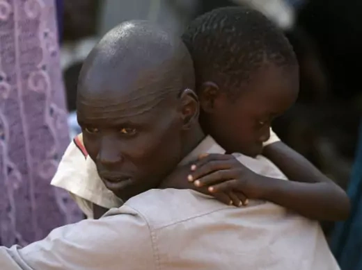An internally displaced man holds his son inside a United Nations Missions in Sudan (UNMIS) compound in Juba December 19, 2013.