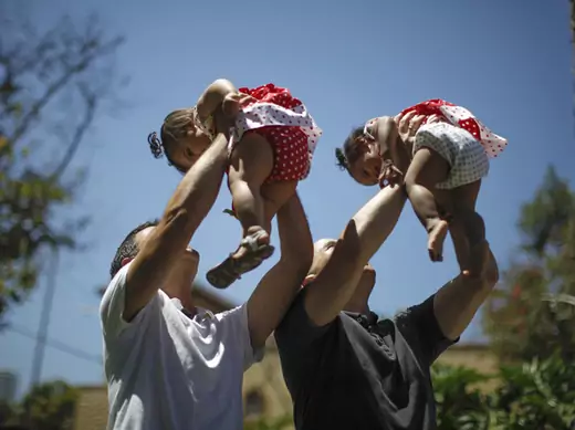 Jason Howe and Adrian Perez (L) hold their one-year-old twin daughters Clara (R) and Olivia at a playground in West Hollywood, California (Lucy Nicholson/Courtesy Reuters).