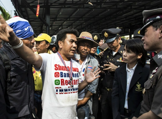 An anti-government protester (C) negotiates with a local official and police officers regarding the closing of a polling station after protesters blocked its entrance during advance voting for a general election in Bangkok on January 26, 2014. (Nir Elias/Courtesy Reuters) 