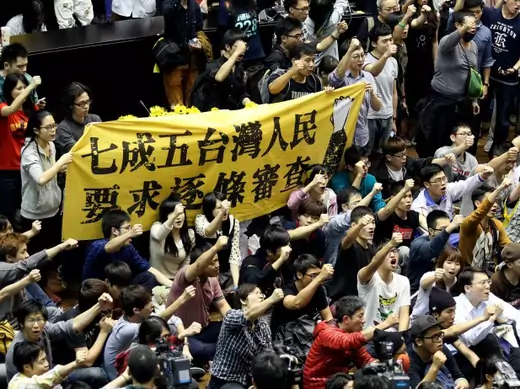 Protestors in Taiwan’s legislature in Taipei hold a banner, “Seventy-five percent of Taiwanese people demand item-by-item review,” on March 19, 2014. (Patrick Lin/courtesy Reuters)