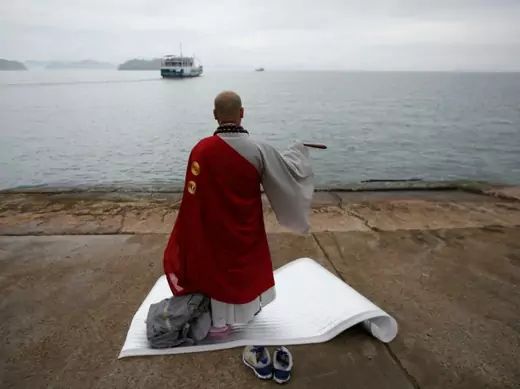 A Buddhist monk prays for the missing passengers on the South Korean ferry, Sewol on April 18, 2014. The ferry had been en route to Jeju, a holiday island off South Korea’s southern coast, when it sent a distress signal on April16 (Issei Kato/Courtesy: Reuters). 