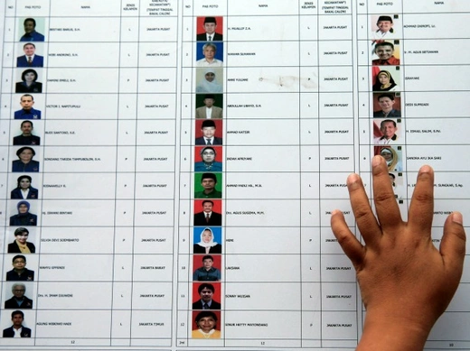 A woman places a hand on a list of candidates for members of parliament at a polling station during voting for parliamentary elections in Jakarta on April 9, 2014. Indonesians voted for a new parliament on Wednesday in a poll that was dominated by the opposition Indonesian Democratic Party-Struggle (PDI-P), boosting the chances of its popular candidate in a presidential election three months from now (Beawiharta/Courtesy: Reuters).