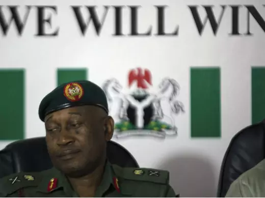 Nigerian army spokesman Major General Chris Olukolade sits in front of a poster reading "we will win" at a news conference in Abuja May 19, 2014.