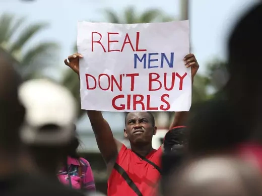 A man holds a placard as youths protest the release of abducted school girls in the remote village of Chibok, in Lagos May 10, 2014.