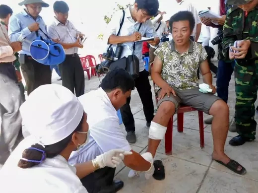 A fisherman (C) receives medical treatment upon his arrival home, after his boat was rammed and then sunk by Chinese vessels near disputed Paracels Islands, at Ly Son island of Vietnam's central Quang Ngai province May 29, 2014. (Stringer/Courtesy Reuters)