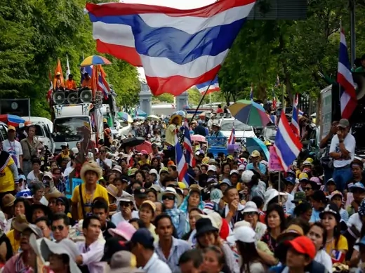 Anti-government protesters wait for their leader Suthep Thaugsuban to come out from the parliament building to address them in Bangkok on May 9, 2014. Thai police fired tear gas on Friday at royalist protesters bent on bringing down a caretaker government after a court threw Prime Minister Yingluck Shinawatra out of office and an anti-graft agency indicted her for negligence (Damir Sagolj/Courtesy: Reuters).