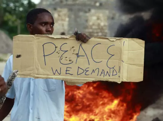 A resident holds a placard as he participates in a protest against the recent attack by unidentified gunmen in the coastal Kenyan town of Mpeketoni, June 17, 2014. (Joseph Okanga/Courtesy Reuters) 