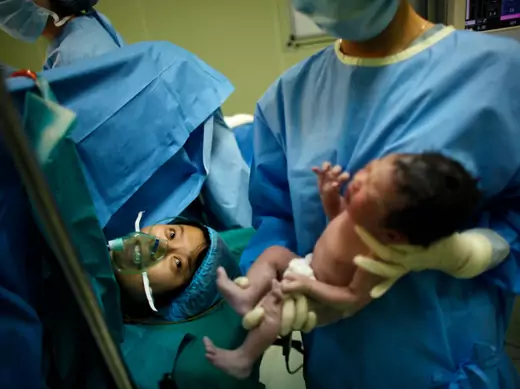 Yang Huiqing looks at her baby after a cesarean section in Ruijin Hospital in Shanghai