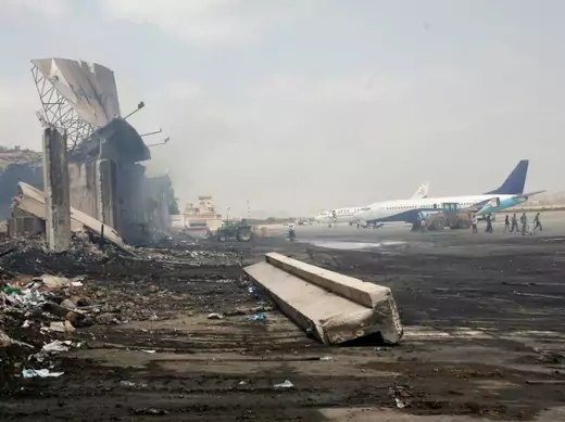 Planes are seen near a section of a damaged building (L) at Jinnah International Airport, after Sunday's attack by Taliban militants, in Karachi June 10, 2014.  (Athar Hussain/Courtesy Reuters)