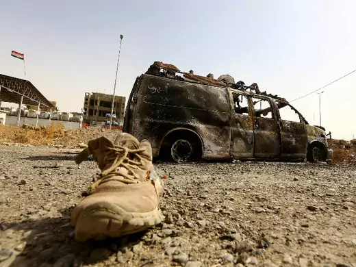 A burnt vehicle belonging to Iraqi security forces is pictured at a checkpoint in east Mosul, one day after radical Sunni Muslim insurgents seized control of the city, June 11, 2014 (Courtesy Reuters).