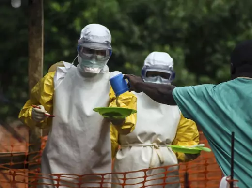 Medical staff working with Medecins sans Frontieres (MSF) prepare to bring food to patients kept in an isolation area at the MSF Ebola treatment center in Kailahun, Sierra Leone, July 20, 2014 (Tommy Trenchard/Courtesy Reuters).