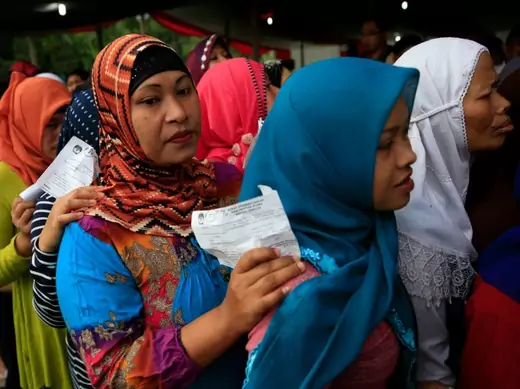 Villagers line up to vote in the country's presidential election at Bojong Koneng polling station in Bogor July 9, 2014. Indonesians began voting on Wednesday in a presidential election that has become a closely fought contest between the old guard who flourished under decades of autocratic rule and a new breed of politician that has emerged in the fledgling democracy. Only the third direct election for president in the world's fourth-most populous nation, the contest pits former special forces general Pra
