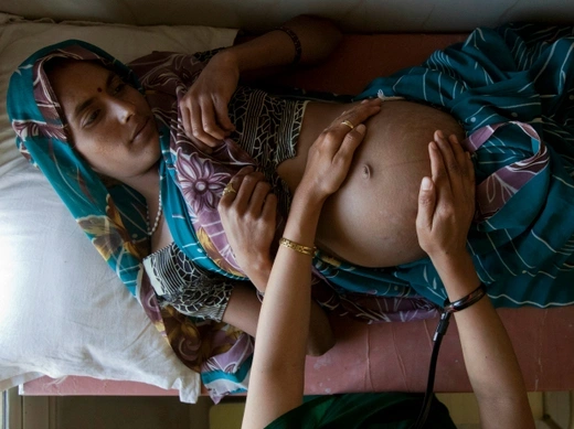 A pregnant woman lies on an examination table during a checkup at a community health center in the remote village of Chharchh, in the central Indian state of Madhya Pradesh, February 2012 (Courtesy Reuters/Vivek Prakash). 