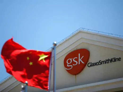 A Chinese national flag flutters  in front of  a GlaxoSmithKline (GSK) office building in Shanghai on July 12, 2013. 