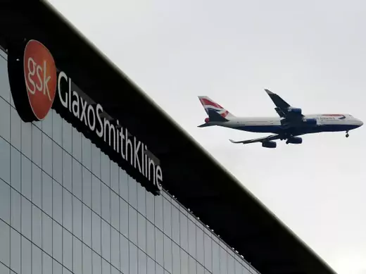 A British Airways airplane flies past a signage for pharmaceutical giant GlaxoSmithKline (GSK) in London on April 22, 2014. (Luke MacGregor/Courtesy Reuters)